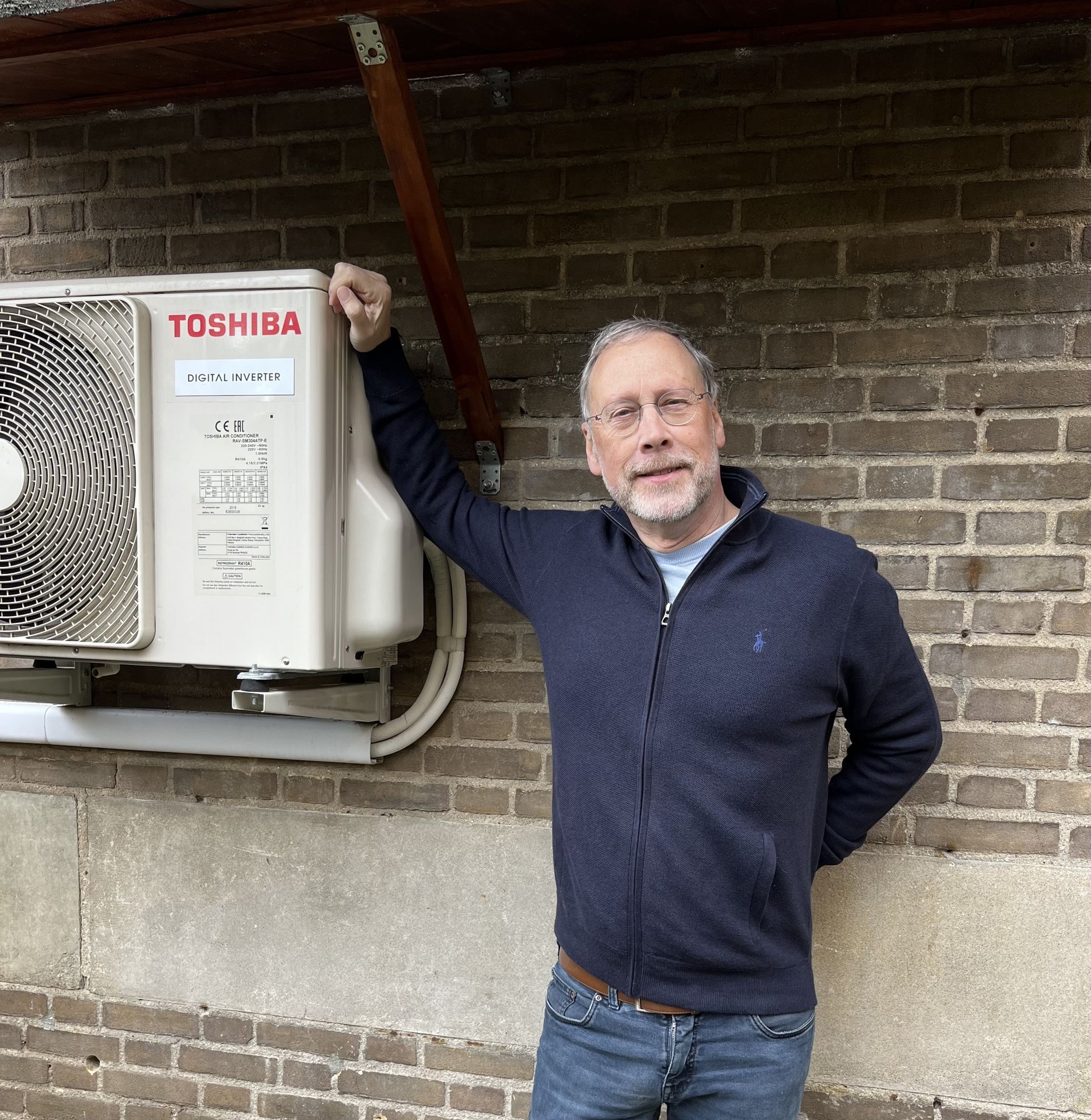gerard staat trots bij zijn hybride warmtepomp